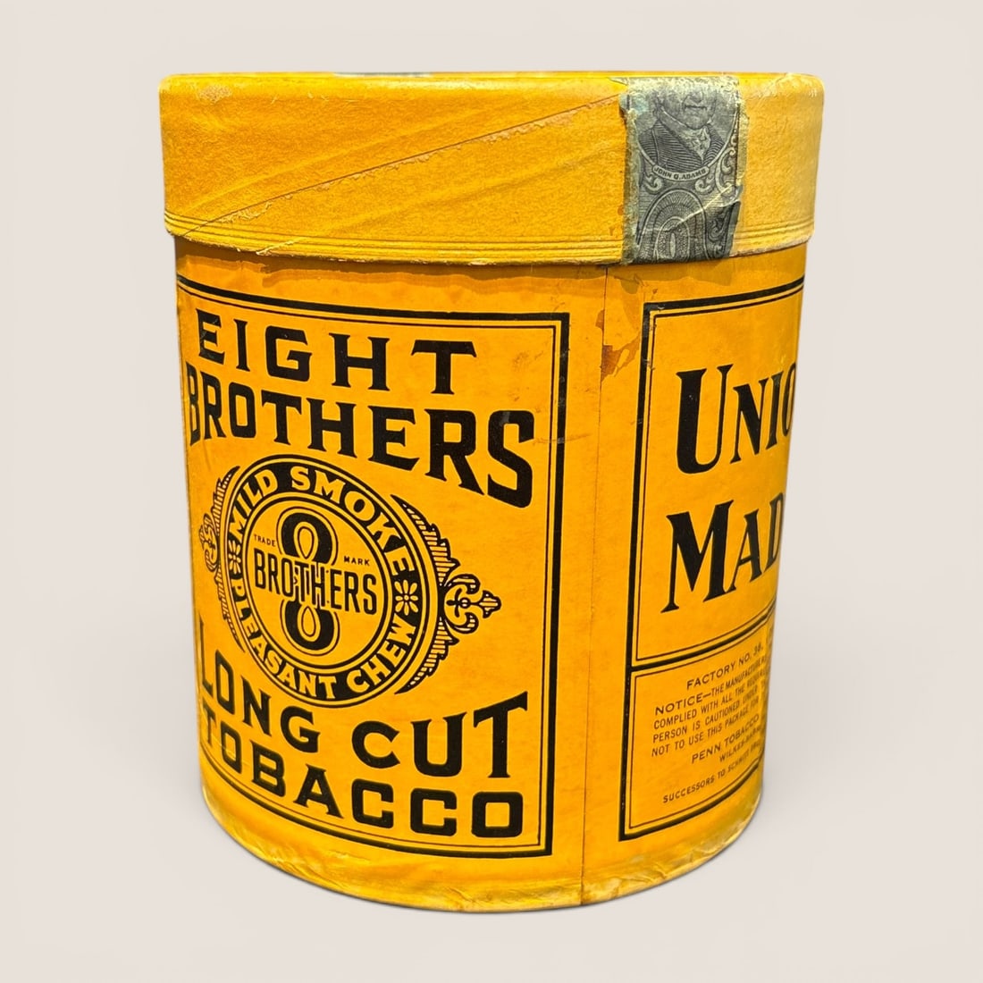 Vintage Eight Brothers Long Cut Tobacco Cardboard Canister: A vintage Eight Brothers Long Cut Tobacco canister manufactured by the Penn Tobacco Company of Wilkes-Barre, Pennsylvania. The cylindrical container features a cardboard body wrapped in bright yellow 