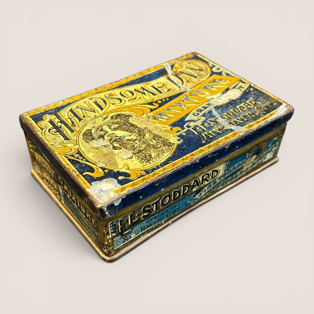 Handsome Dan Mixture Lithographed Tobacco Tin for L.L. Stoddard: This vintage rectangular tobacco tin is constructed of lithographed metal and was produced for L.L. Stoddard, a retailer based in New Haven, Connecticut. The lid features a central portrait of the Yal
