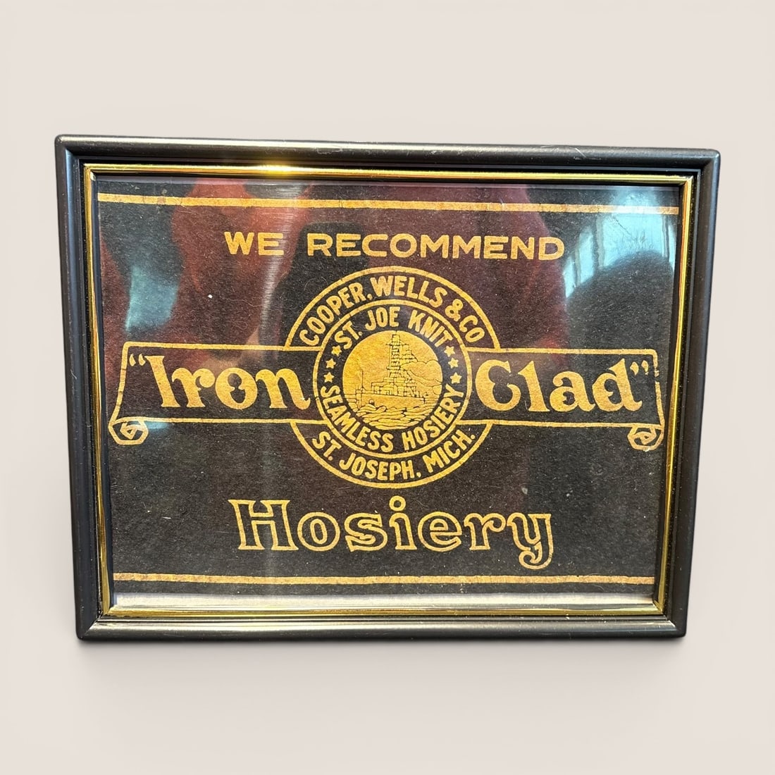 Vintage Iron Clad Hosiery Framed Felt Advertising Store Sign by Cooper, Wells & Co.: This is a vintage framed advertising display for Iron Clad Hosiery, produced by Cooper, Wells & Co. of St. Joseph, Michigan. The sign consists of a black felt board with gold-tone printed graphics and