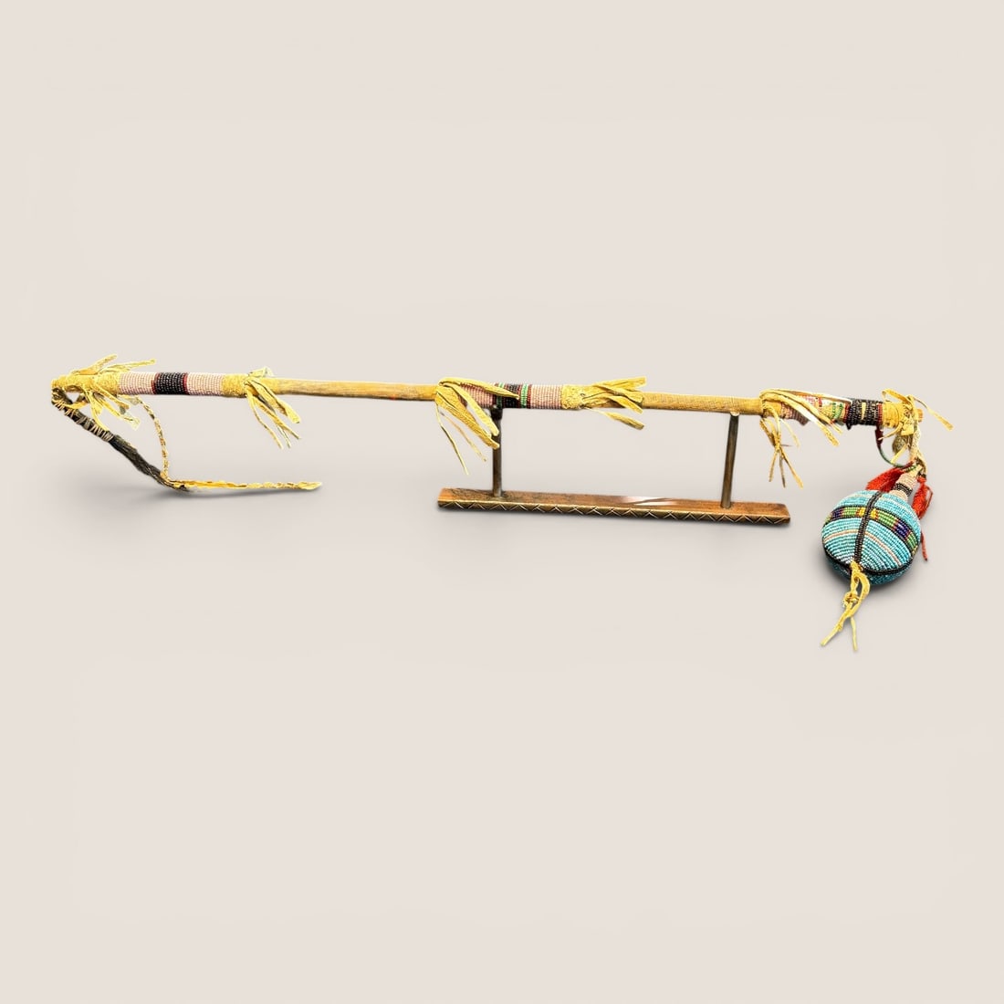 19th C Plains Beaded Skull Cracker Club: Measures approx 30 inches overall with beaded handle, and beaded stone at end. Sinew sewn. circa 1890. Likely Sioux, or Northern Plains.We provide in-house shipping on all items in the auction. Bid