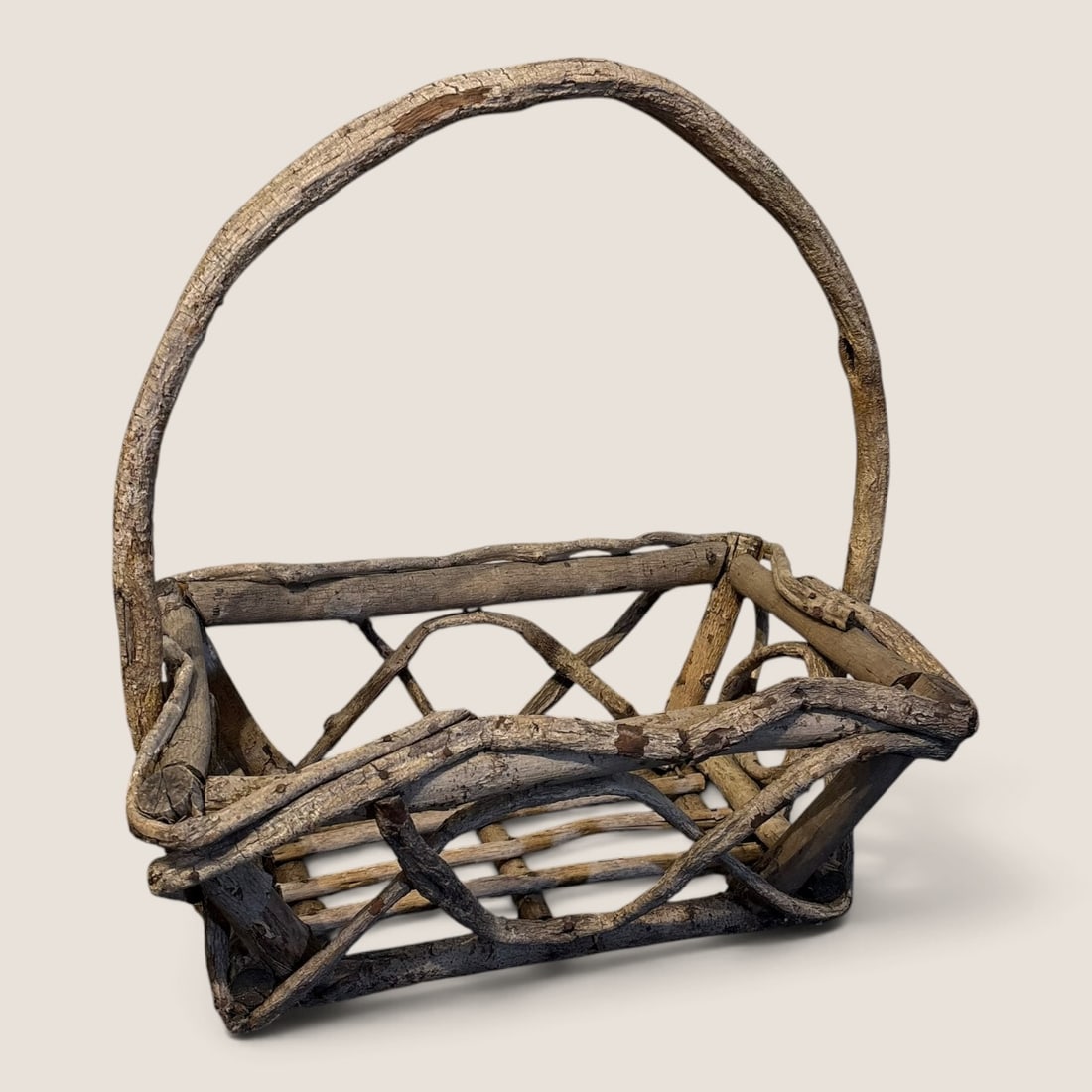 Adirondack Style Rustic Twig and Branch Gathering Basket: A rustic garden or gathering basket handcrafted from natural, unpeeled hardwood branches and twigs. The rectangular basket features an openwork lattice design on the sides created by interlaced, curve