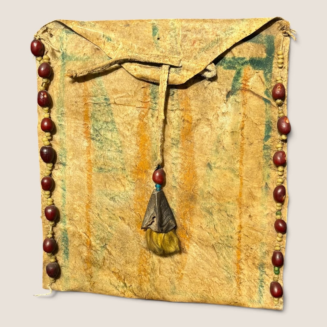 Plains Parfleche Envelope: Measures approx 9 x 8 3/4 inches, with dried berries, seed beads, and a dew clear for decoration. A unique parfleche.We offer effecient & affordable in-house shipping on all items in this auction.