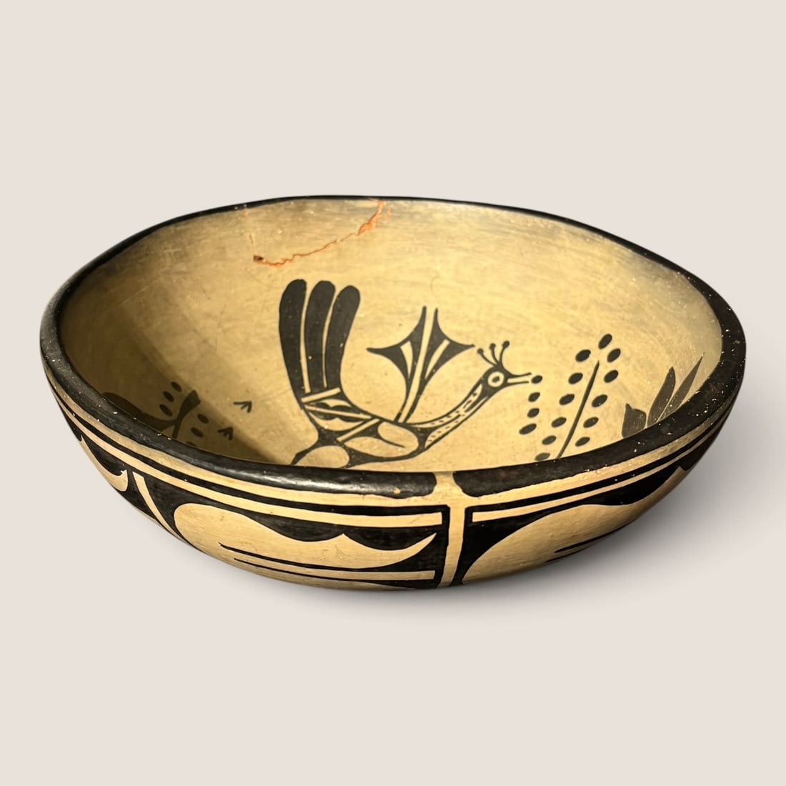 Santo Domingo Pottery Bowl: Measuring approx 10 x 4 inches, with a broken piece to rim that has been reglued. Signed at bottom in pencil. Signed Crucita Melohor.We offer effecient & affordable in-house shipping on all items in