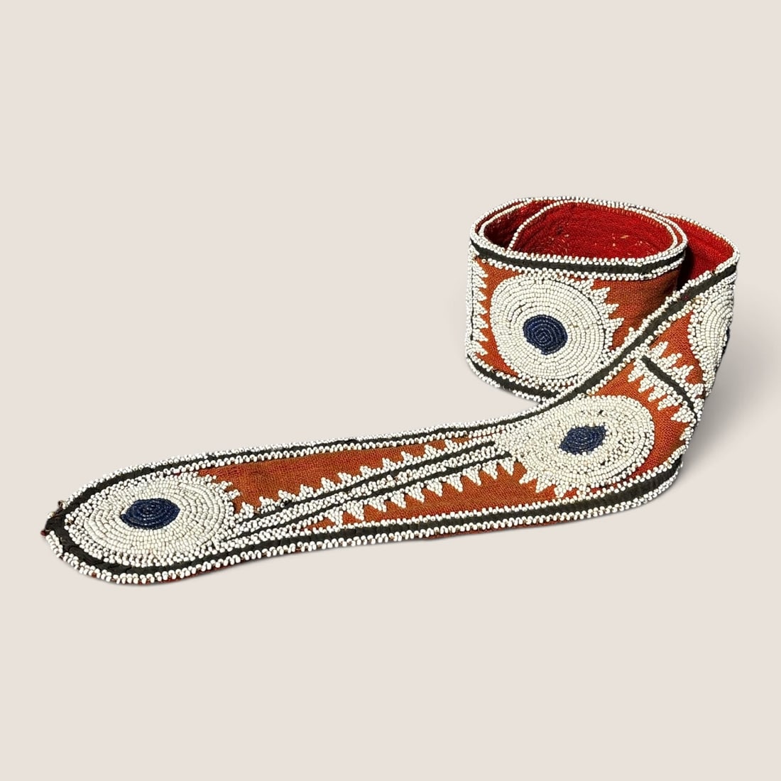 Rare Southern (Choctaw) Beaded Belt/Sash: Circa 1850-1860, a rare example of a Choctaw strap. Beaded on side with white and blue beads, on red trade cloth. Measures approx 45 inches overall x 3 1/4 inches wide. A rare example.We offer