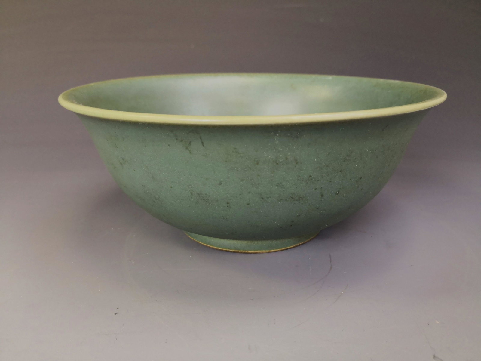 China, Celadon Conical Bowl: sturdily potted with deep rounded sides rising from a short foot to a flaring rim, evenly covered overall save for the footring in a celadon glaze, the base inscribed in underglaze blue with a six-cha