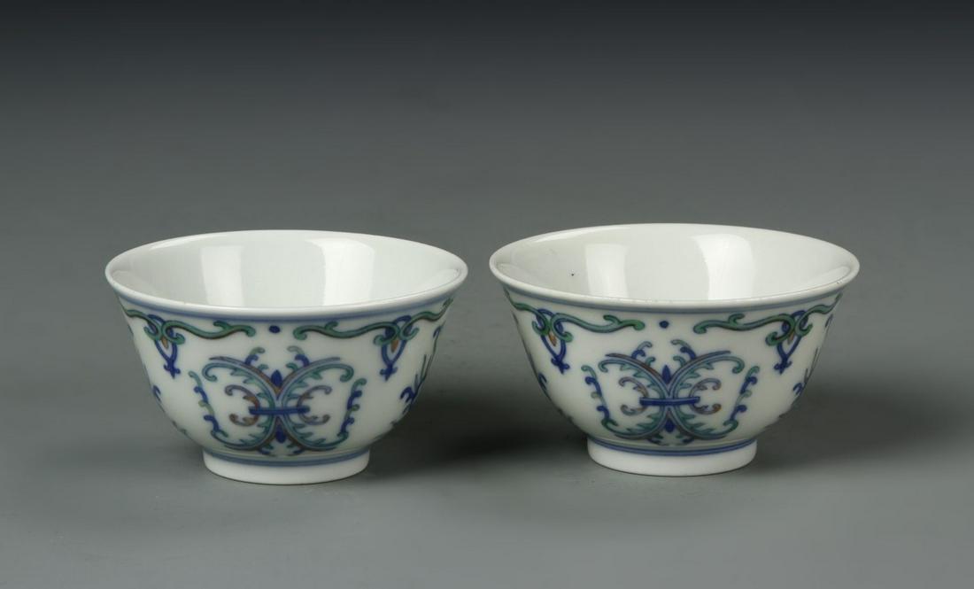 Chinese Doucai Wine Cups: China, 19th C., pair of Doucai wine cups, slightly flared rims, high sides on footed base, plain interior with blue designs on exterior against white ground, mark on base. Width 2 1/2 in., Height 1 1/
