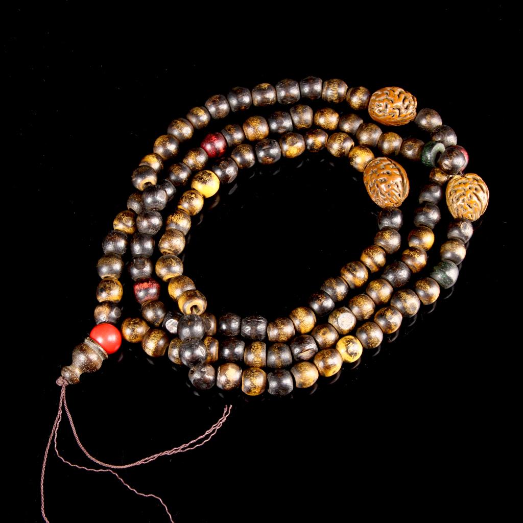 Chinese Walnut Prayer Beads: China, prayer beads, consisting of several loops of rounded beads or varying tones, separated by carved walnuts, with a red bead at the center with a split tassel.Length 21 in.