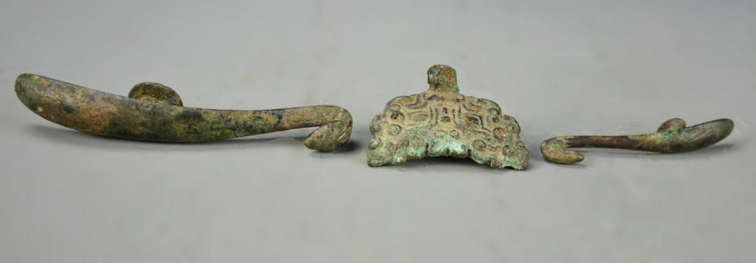 Three Chinese Bronze Belt Hooks: China, three bronze belt hooks, two carved in the form of bird heads, the other in a geometric form, all with heavy patina. Longest Length 5 in.
