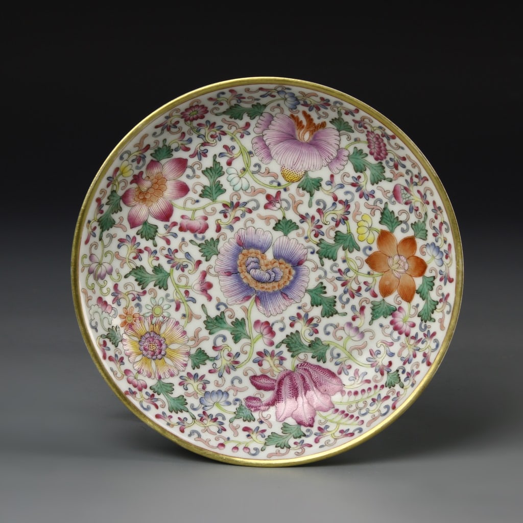 Chinese Famille Rose Plate: China, 19th C. Famille rose plate, deep potted dish with gilt rim, dense central decoration of floral and green leaf design, Qianlong mark on plain base. Diameter 6 1/8 in.