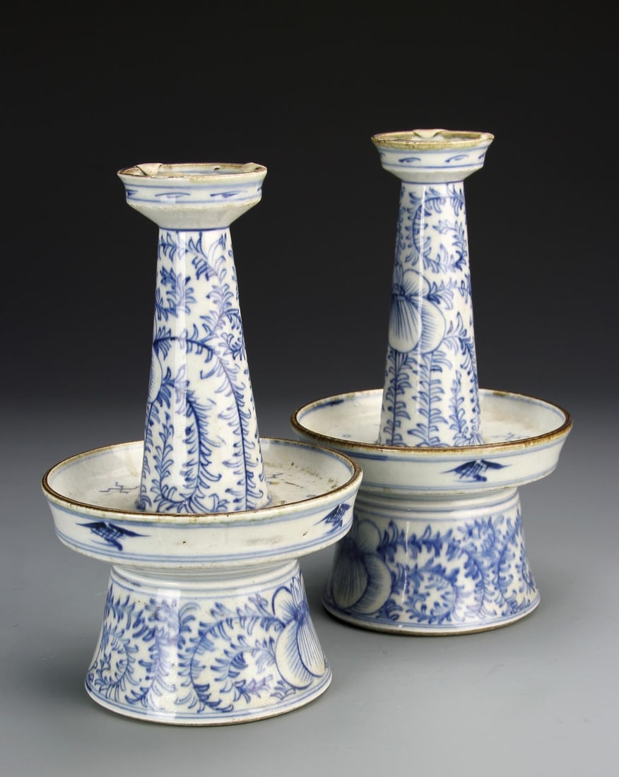 Pair of Chinese Blue and White Candle Holders: China, 18th C., pair of blue and white candle holders, with flared shoulders, narrow necks and flared lips, and decorated with loosely rendered floral designs and auspicious symbols. Height 8 3/4 in.