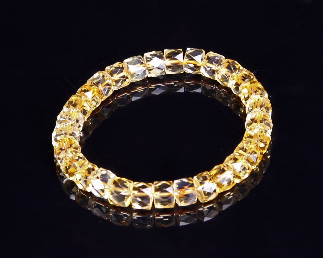 Chinese Yellow Crystal Necklace: China, yellow crystal necklace comprised of round beads with multi-faceted surfaces in a transparent, light yellow color, strung along a gold-colored cord. Length 3 in.