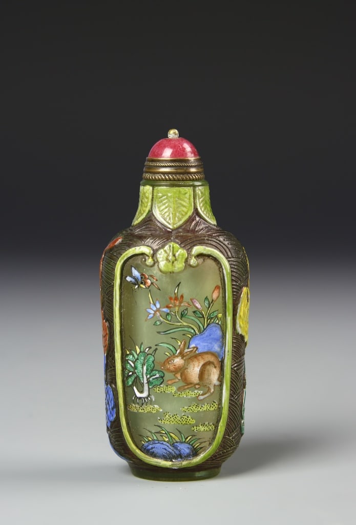 Chinese Peking Glass Snuff Bottle: China, Peking glass snuff bottle, decorated with panels showing rabbits in a garden landscape, against criss cross designs and a dome shaped stopper. Height 3 1/8 in.