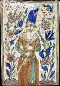 A Persian Qajar Porcelain Title: A Persian Qajar porcelain tile, likely from the 19th century. oThe tile depicts a Persian prince holding a sword, surrounded by scrolling foliage, flowers, and birds. 13 1/2” X 9 1/4” X 1/