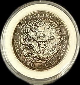 A Chinese Qing Dynasty silver coin, likely a "Dragon Dollar," (1 of 2)