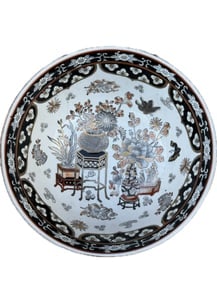 A vintage Chinese porcelain bowl, likely a "Famille Noire" style bowl: A vintage Chinese porcelain bowl, likely a "Famille Noire" style bowl due to its prominent black and white or black and red enameling. This type of porcelain originates from China and is known for its