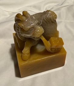 Chinese Yellow Jade Seal: Chinese collectible, specifically a carved yellow jade-style seal, featuring a mythical beast, often a lion, Foo Dog, or Pixiu, on the top, which symbolizes protection and wealth and Chinese character