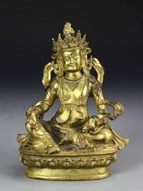 Antique Chinese Tibetan Gilt Buddha: China, 19th C., Tibetan Gilt Buddha, seated figure wearing tiered crown, legs crossed with small mythical creature in one hand, floral mark on base. Height 9 1/2 in.