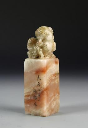 Antique Chinese Shoushan Seal Chop: China, Antique Shoushan stone seal chop, of a mottled peach hue, smoothly carved , topped with a carved foo dog, with gilt incised Chinese calligraphy. Height 4 3/4 in.