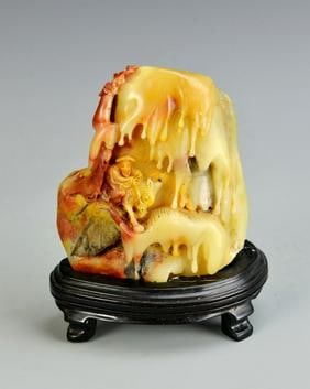 Antique Chinese Shoushan Boulder: China, antique Shoushan boulder, with carved figure on a horse, in a mountainous landscape, with mottled red and orange hues, and on stand. Height 4 in.