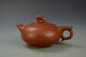 Chinese Yixing Teapot: China, Yixing teapot, round body, extended looped handle and short spout, decorated with calligraphy on one side and floral sprigs on the other. Height 3 1/2 in., Width 6 3/4 in.