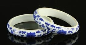 Pair of Chinese Blue and White Bangles: China, a pair of blue and white bangles, each with the outside decorated with a repeating scrolling lotus pattern, the interior a plain white glaze. Diameter 3 1/4 in.