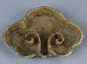 Chinese Carved Jade Dish: China, 19th C., carved jade dish, in the shape of a ruyi mushroom head, with natural striations and curved rim and incised scroll detail. Width 3 1/2 in., Height 2 1/2 in.