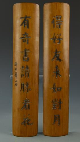 Pair of Antique Chinese Bamboo Wrist Rests: China, Qing Dynasty, a pair of Chinese bamboo wrist rests, oblong body with rounded ends, straight bordered sides, calligraphy carved into both centers. Length 13 in., Width 2 1/2 in.