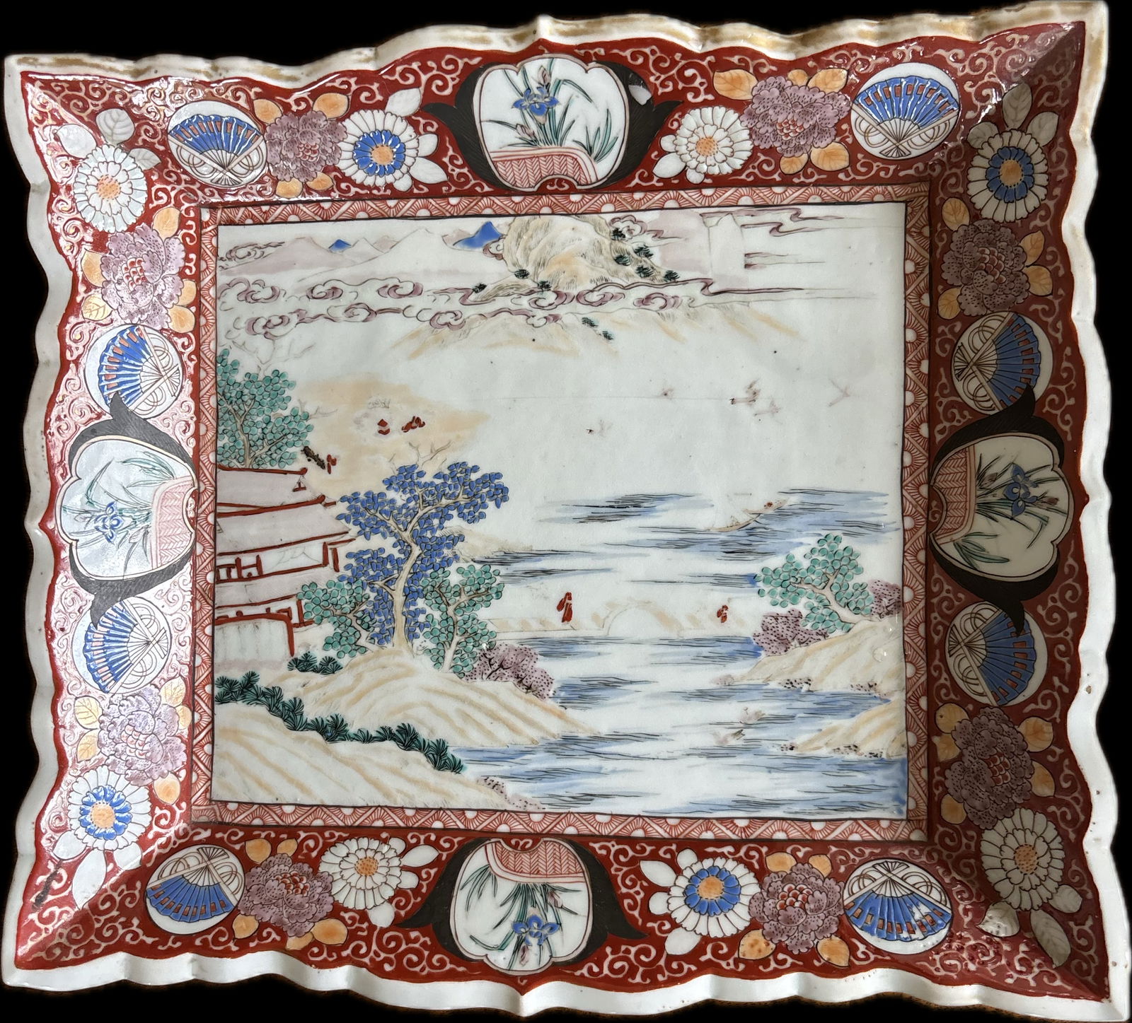 Antique Japanese Imari porcelain charger: Antique Japanese Imari porcelain charger, typically characterized by a vibrant color palette of underglaze blue, iron-red, and gold enamels, signed by the artist on back, 12” x 10”