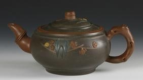 Chinese Yixing Teapot: China, 20th C.,green teapot with brown and yellow embellishments; handle, spout and lid in the form of branches, marking on base. Width 7 1/2 in., Height. 3 1/2 in.