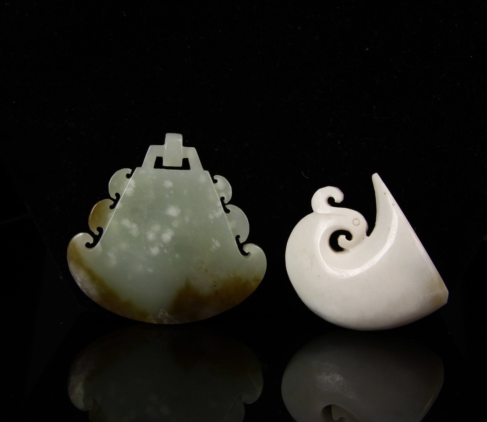 Chinese Antique Cup and Pendant: China, antique cup and pendant, one of a mottled green hue, the other bright white, both smoothly carved with geometric designs, and a smooth, high shine surface. Height 1 1/4 in.