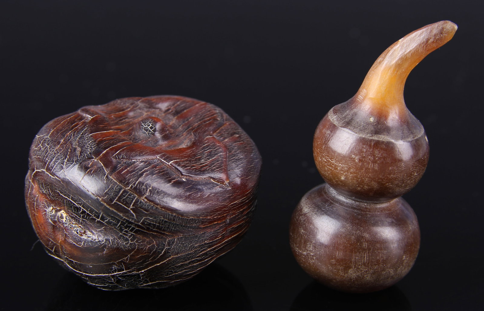 Two Chinese Carved Horn Items: China, two carved horn items, one in oval shape with carving around the middle and top, the other in a gourd shape with pointed top. Height 1 3/4 in. Federal regulations prohibit the shipment of horn.