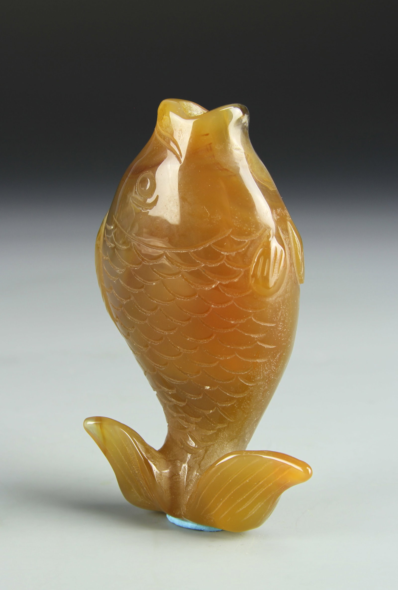 Chinese Carved Agate Snuff Bottle: China, 19th C., carved agate snuff bottle, smoothly carved into the form of a fish, with great detail incised in the scales, mouth and splayed fins of the animal, in an orange hue. Height 3 1/2 in.