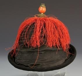 Chinese Qing Dynasty Officer's Hat: China, Qing Dynasty, officer's hat with a carved finial in brass and a round orange stone, hat is rich dark, black color, with generous amount of brightly orange colored fringe. Diameter 11 in.
