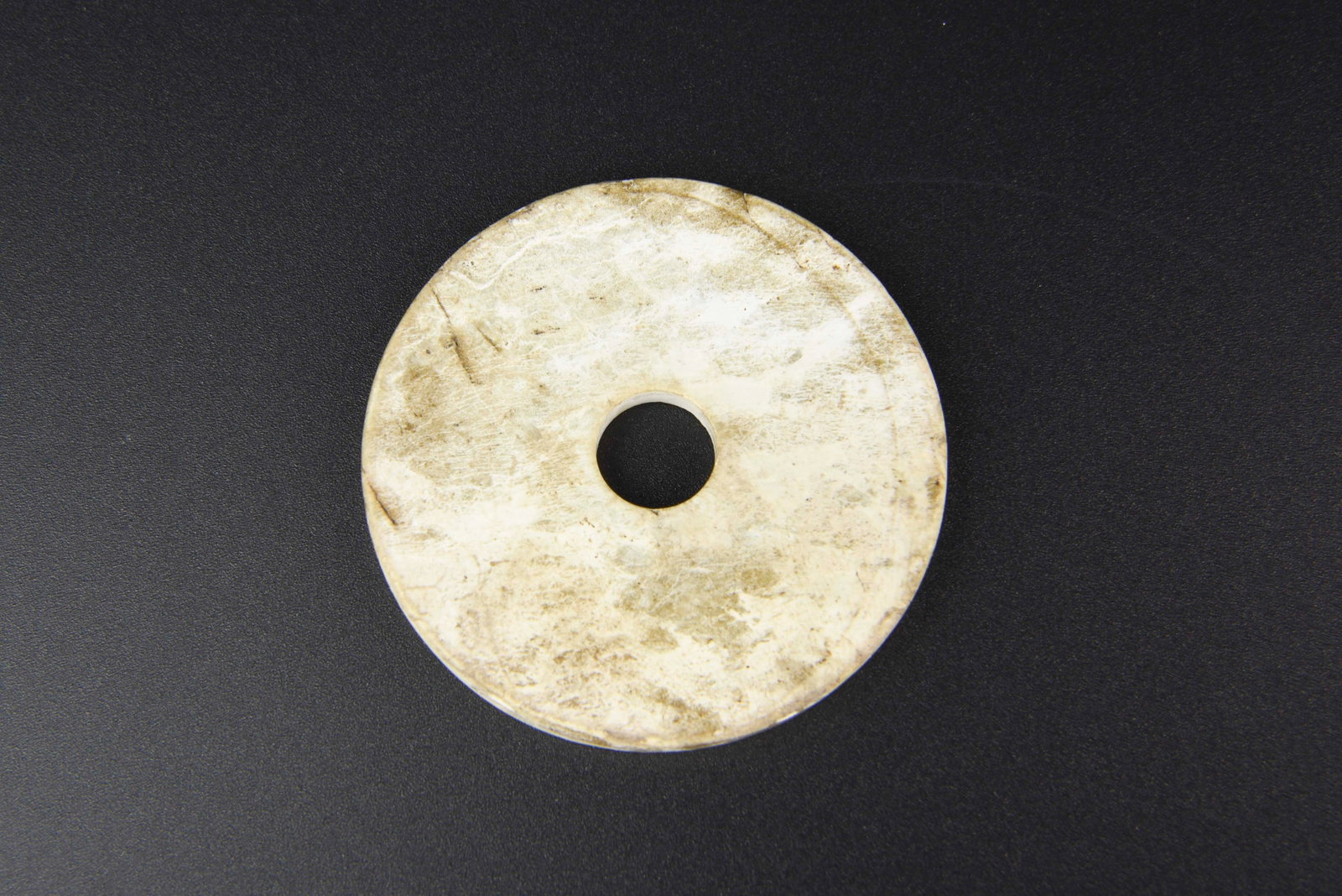 Chinese Jadeite Pendant: China, 19th C., jadeite pendant, smoothly carved, the face decorated with organic and floral motifs, a small feline animal at the base, in a mottled green and white hue. Height 2 1/8 in.