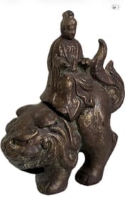 Antique Chinese bronze sculpture depicting a deity or arhat riding a mythical lion: Antique Chinese bronze sculpture depicting a deity or arhat riding a mythical lion (shishi or kylin). It shares characteristics with historical okimono figures or Buddhist guardian sculptures often us