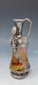 Vintage Art Nouveau claret jug or ewer: A vintage Art Nouveau claret jug or ewer. It is a type of pitcher or decanter used for serving wine.The jug features a silver-plated handle, spout, and base with floral designs characteristic of the A