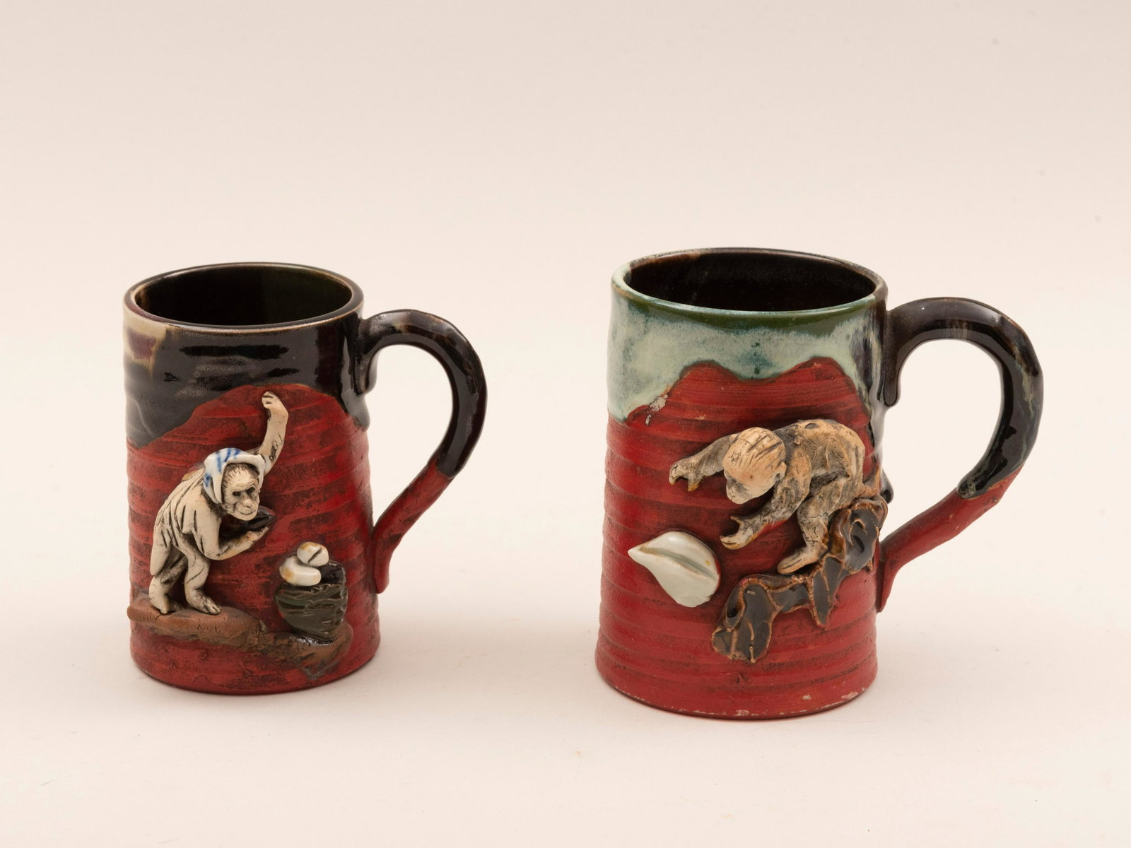 Two Japanese Sumida Gawa Art Pottery Mugs with Applied: Two Japanese Sumida Gawa Art Pottery Mugs with Applied Monkeys each signed on the reverse. Heights: 5 and 4 1/2 inches