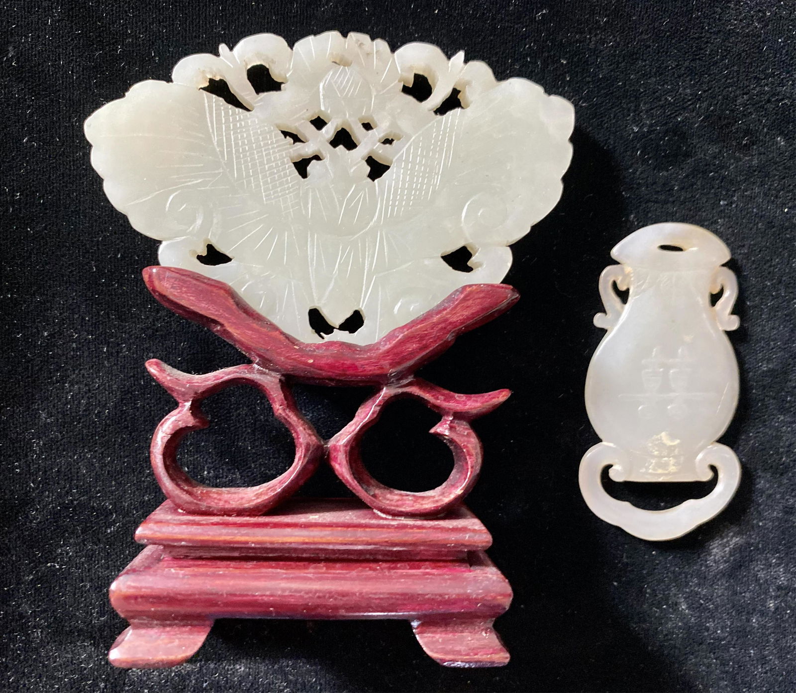 Two celadon jade pendants, one on wood stand, late (1 of 2)