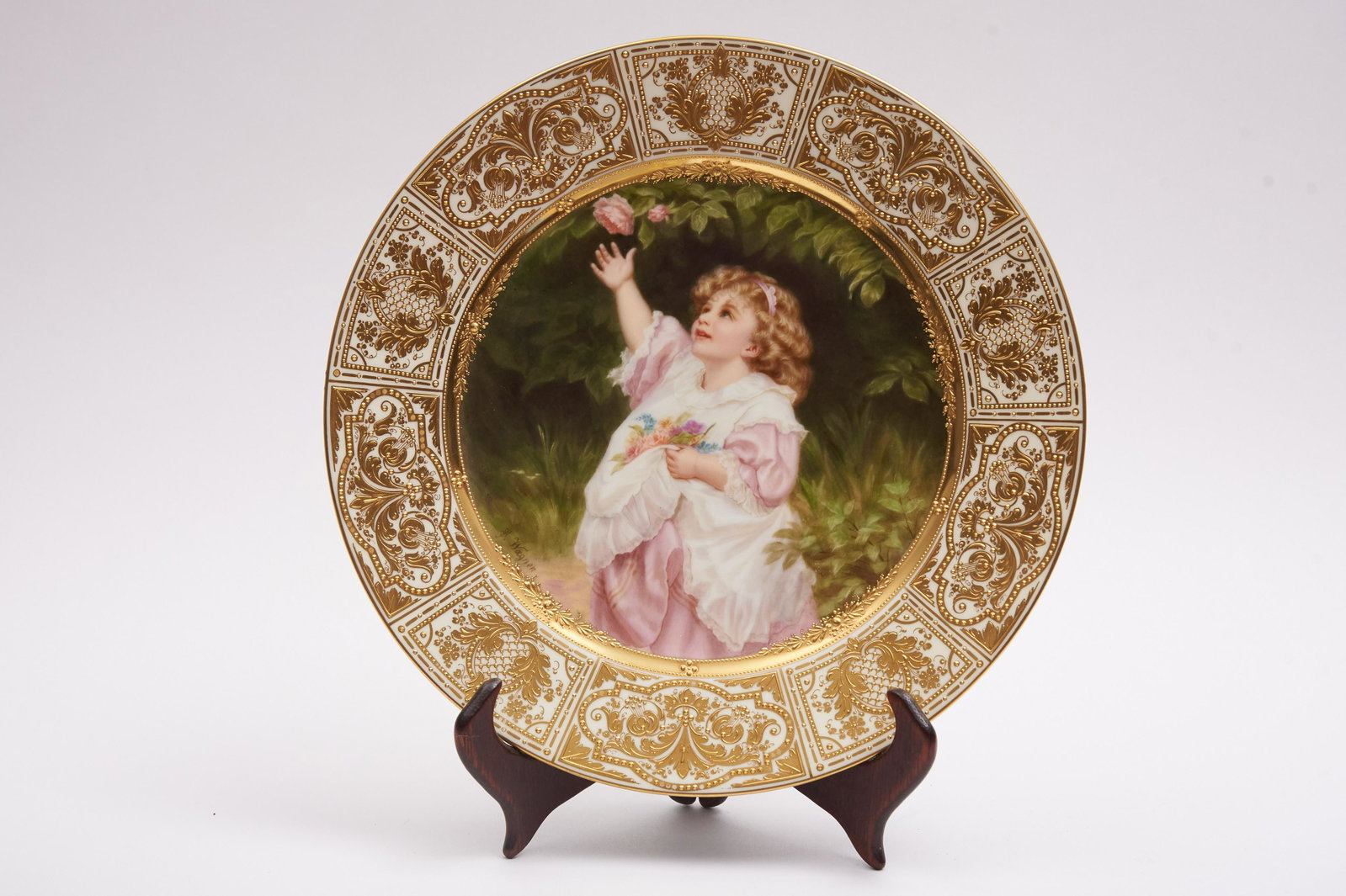 Royal Vienna Portrait Plate, "Kleine Gartnerin", signed: Royal Vienna Portrait Plate, "Kleine Gartnerin", signed Wagner Nicely painted and gilded portrait plate depicting a young child gathering flowers Beautiful high relief gilding to border Fain