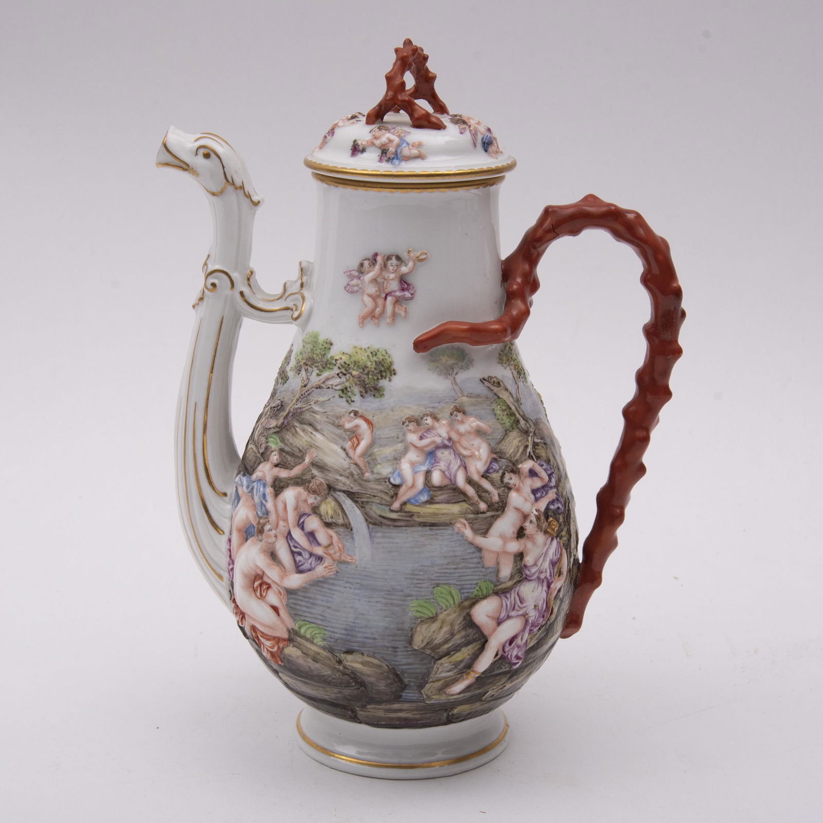 Early Naples or Capodimonte Teapot 8" Tall: Early Naples or Capodimonte TeapotThe well molded body depicting figures frolicking in a lake setting. The handle and lid molded in a coral motif with multiple cupids on the lid. Dragon style spout.Th
