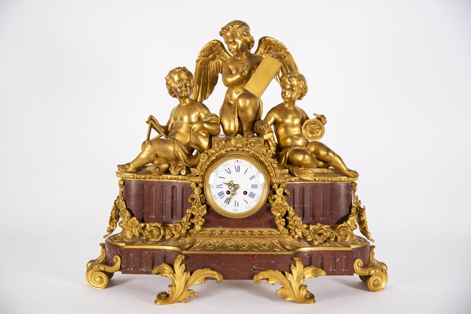 A Monumental French Gilt Bronze and Rouge Marble Clock,: A Monumental French Gilt Bronze and Rouge Marble Clock, the Allegory of Arts and Science A magnificent and large 19th Century clock with 3 putti/cupids; each depicting an element of Art and Science. T