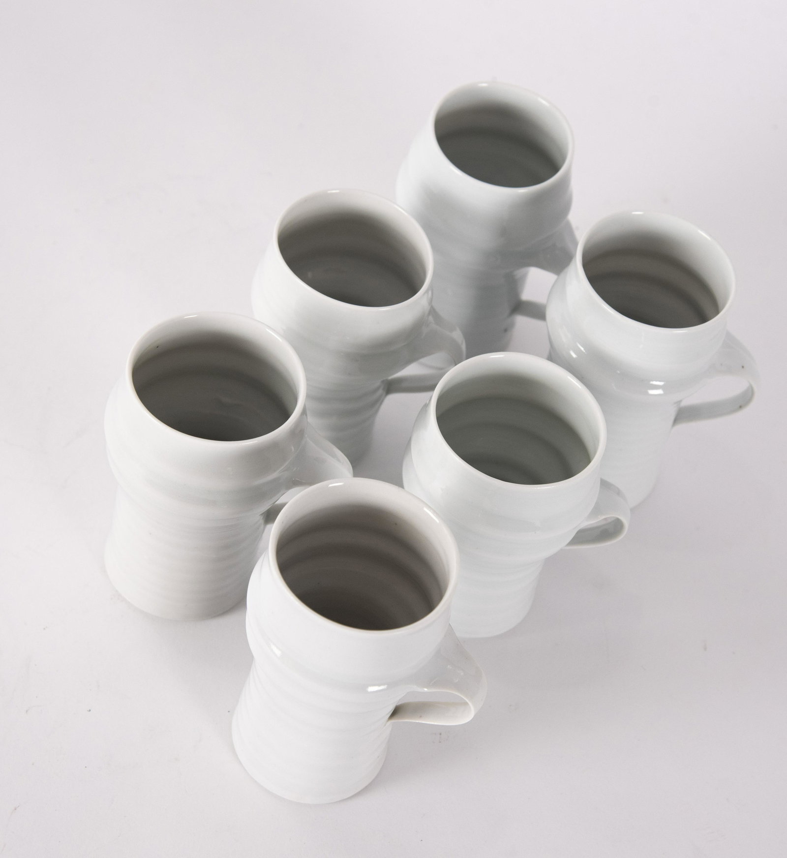 James Makins Six White Glazed Demitasse Cups: James Makins Six White Glazed Demitasse Cupsheight 4 1/2 - 4 3/4 inches, signed "Makins" on underside, James Makins (b.1946) is a ceramic artist known for his use of finger ridges, dimpling,