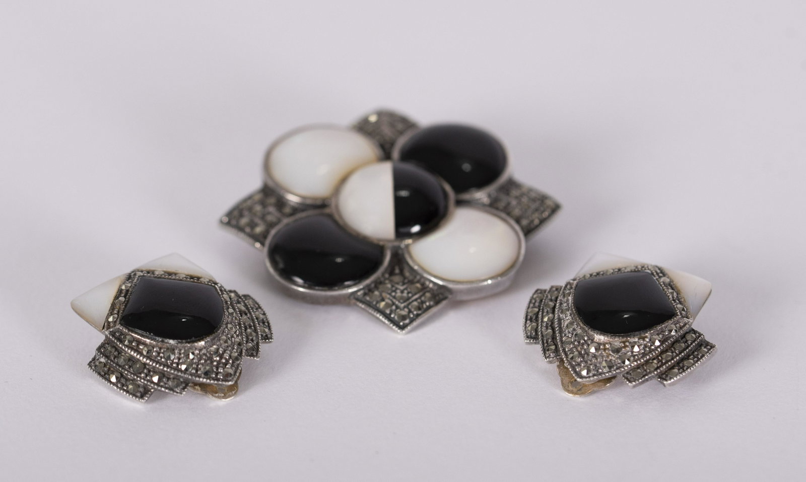 Vintage Marcasite and Sterling Silver Brooch and: Vintage Marcasite and Sterling Silver Brooch and Earrings Sterling silver art deco square marcasite brooch with black onyx and mother of pearl floral design center with matching clip earrings. Excelle