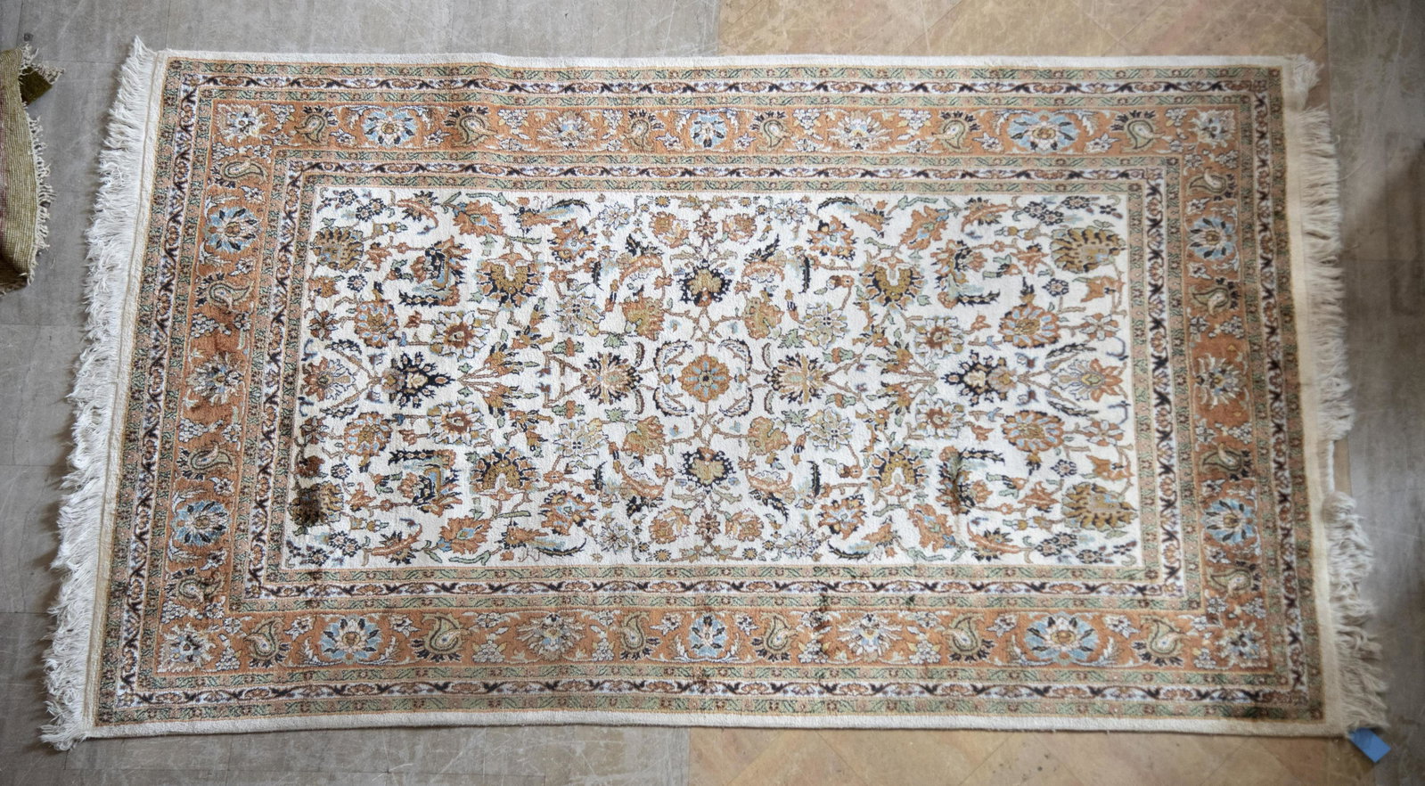 Handwoven Indian Area Rug 4' 11" x 8': Handwoven Indian Area Rug Ivory field with all over foliate and scrolling decoration centering a tan foliate primary border and six guard borders. 4' 11" x 8'
