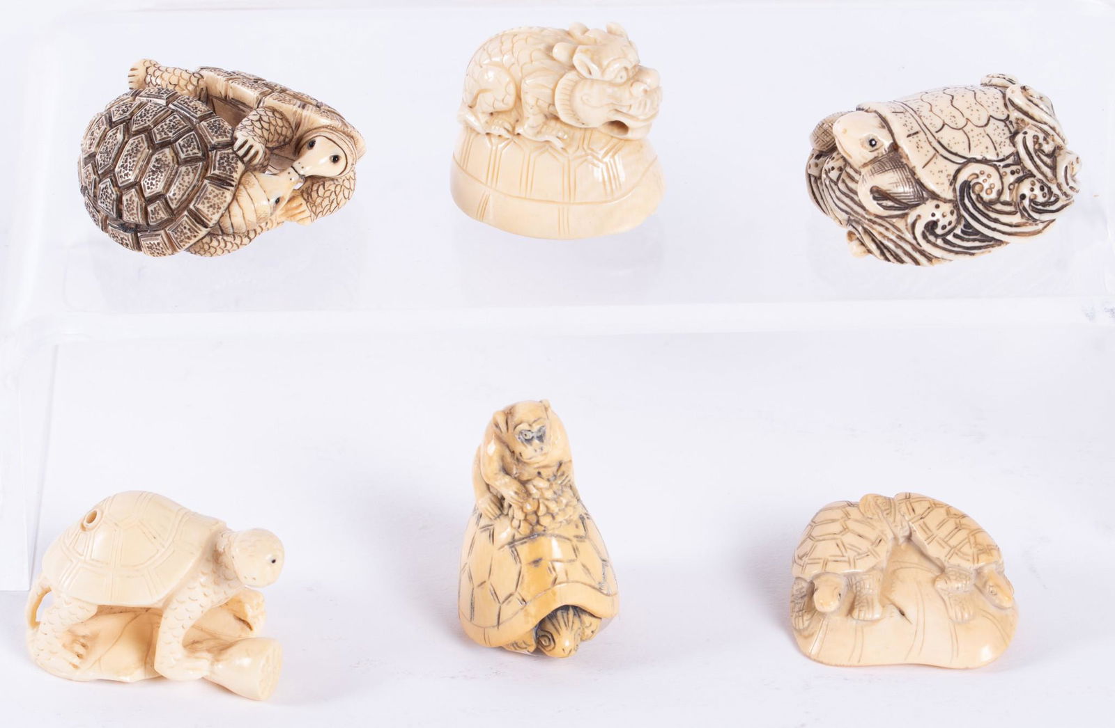 Six Carved Japanese Netsuke Turtles: Six Carved Japanese Netsuke TurtlesIncluding a monkey on a turtle's back, a turtle riding waves, a dragon on turtle, two turtles embracing, two turtles on a lily pad, and a single turtle on a lily pad