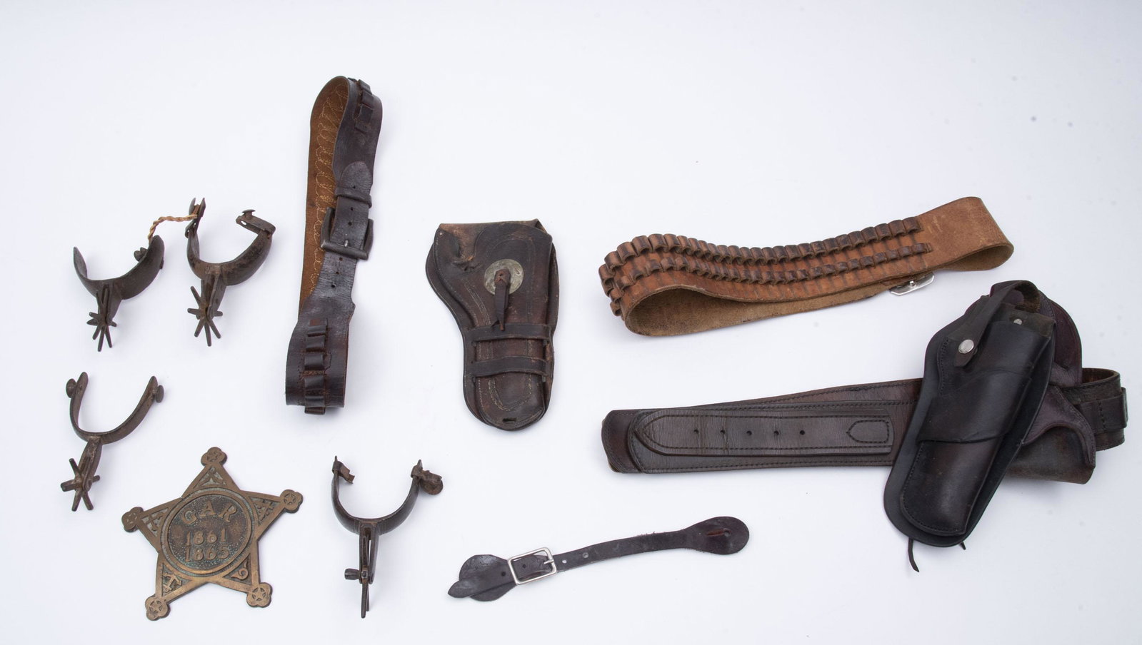 Collection of Early Spurs and holsters: Collection of Early Spurs and holsters Two pairs of spurs (one not matching); three leather gun holsters and belts (one belt is 43" long); together with a G.A.R. metal badge.