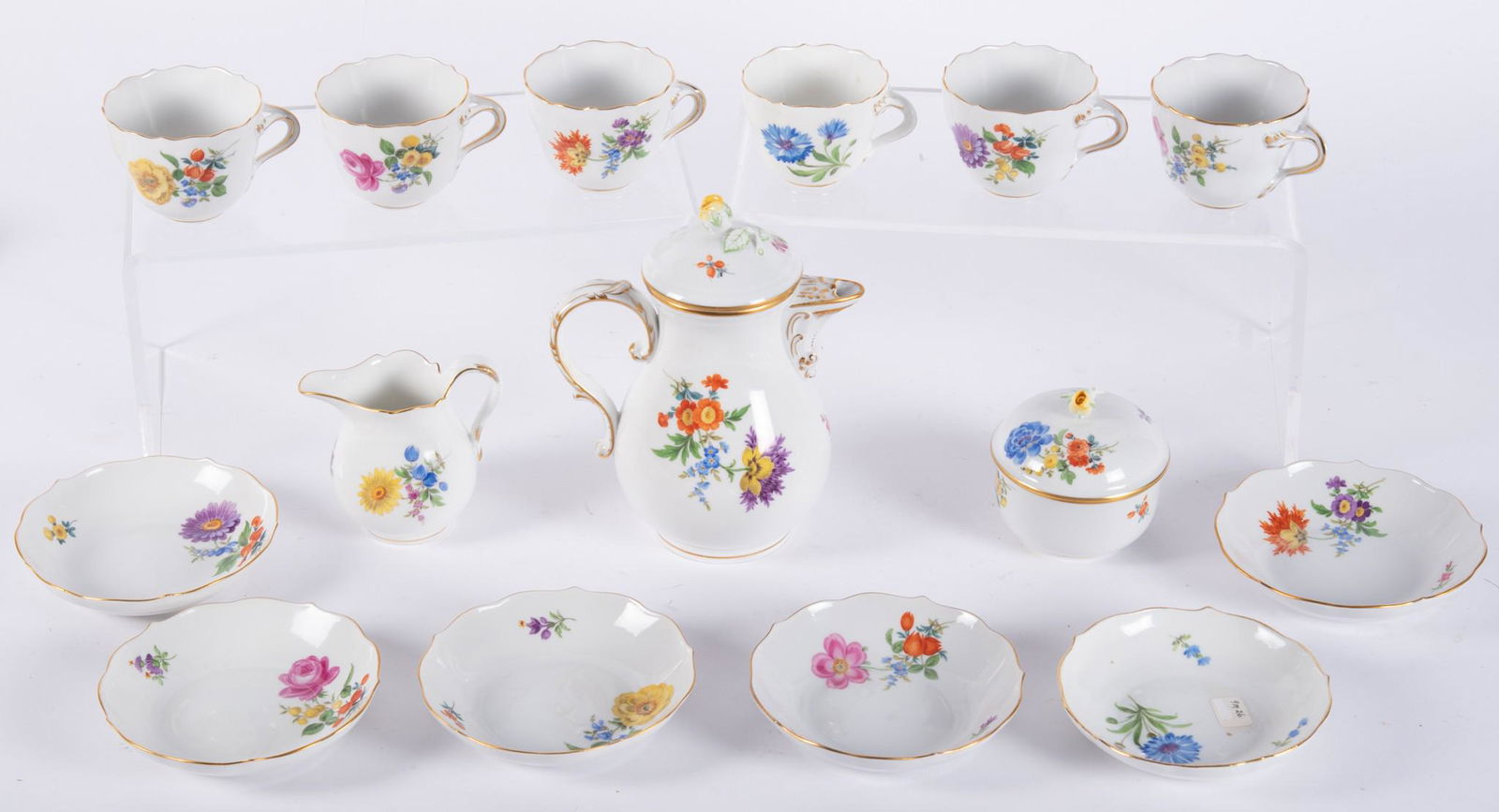 A Meissen Porcelain Tea Set: A Meissen Porcelain Tea SetThe set consisting of a teapot, cream/sugar, six cups/saucers. Each piece painted with floral motifs and gilded highlights, cross swords mark. Teapot height 6 1/2".