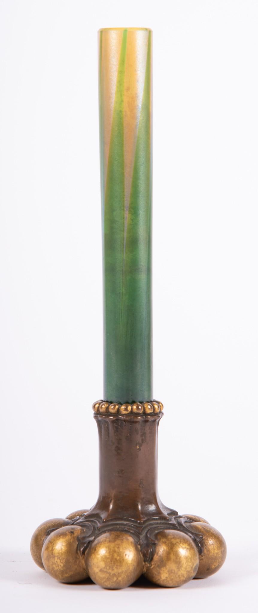 Tiffany Studios Bronze and Favrile Glass Bud Vase: Tiffany Studios Bronze and Favrile Glass Bud Vase The base with ball knob detailing at foot and bead design at rim, marked Tiffany Studios, New York 717. With a pulled feather favrile glass insert, si