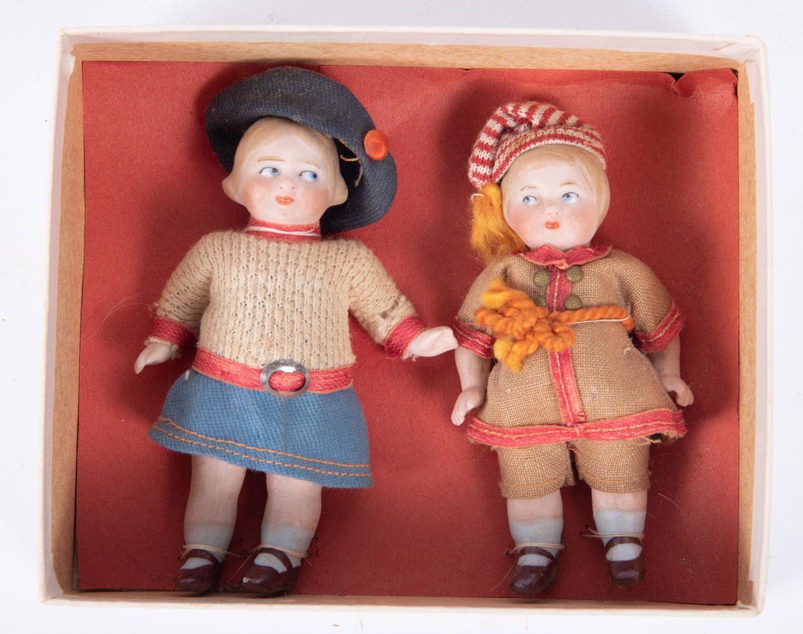 Pair of 4" All Bisque Jointed Dolls, 1920: Pair of 4" All Bisque Jointed Dolls, 1920still attached to the bottom of their box. No top. They are originally dressed and have side glancing eyes with molded blond hair.