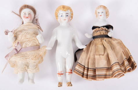 Three Frozen Charlotte Dolls, 1850-1890: Three Frozen Charlotte Dolls, 1850-1890Frozen Charlotte with metallic gold boots, ribbed socks and banded with dark pink ribbon. Blond molded curls, 4" long; Wigged Frozen Charlotte in lace outfi